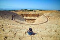 Back view of woman traveler in hat looking at amazing Amphitheater ruins in ancient Hierapolis, Pamukkale, Turkey. Grand panorama