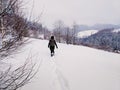 Back view woman walking alone in snowy mountains Royalty Free Stock Photo