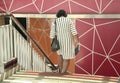 Back view of woman walking down the staircase