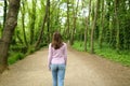 Back view of woman walking in a forest path Royalty Free Stock Photo