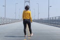 Back view of woman walking in the middle of an empty street Royalty Free Stock Photo