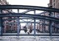 Back view of woman wearing long coat standing on bridge in old warehouse district Speicherstadt in Hamburg Royalty Free Stock Photo