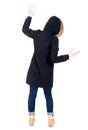 Back view woman in winter jacket Balances waving his arms.