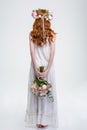 Back view of woman in wreath standing and hiding bouquet Royalty Free Stock Photo