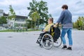 Back view of woman with boy in wheelchair near school building
