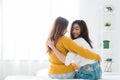 Back view of women lesbian happy couple waking up in morning, sitting on bed, stretching in cozy bedroom. Royalty Free Stock Photo