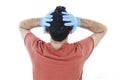 Back view of worried person with virus protection surgical face mask and gloves holding his head in panic, looking at wall.