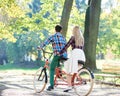 Young couple, handsome man and attractive woman on tandem bike in sunny summer park or forest. Royalty Free Stock Photo