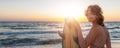 Back view young adult slim sporty female surfer girl with surfboard silhouette stand at ocean coast wave against warm Royalty Free Stock Photo