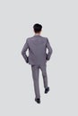 Back view young asian business man in suit walking isolated on white background, portrait of executive or manager. Royalty Free Stock Photo