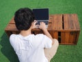 Back view of young Asian man using computer laptop at outdoors. Royalty Free Stock Photo