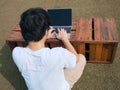 Back view of young Asian man using computer laptop at outdoors Royalty Free Stock Photo