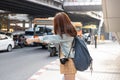 Back view of young Asian travel girl hitchhiking on the road in city. Life is a journey concept Royalty Free Stock Photo