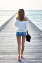 Back view of young beautiful woman walking on the pier Royalty Free Stock Photo