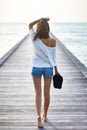 Back view of young beautiful woman walking on the pier Royalty Free Stock Photo