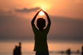 Back view of a young boy silhouette standing and doing Surya Namaskar