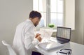 Back view of a young businessman anaccountant working with laptop with tables at the office. Royalty Free Stock Photo