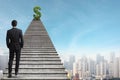 Back view of young businessman climbing stairs with dollar sign on city sky background. Finance, Rich, Success and employment