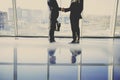 Back view of young businessman is looking out of a panoramic window and talking by phone Royalty Free Stock Photo