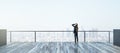 Back view of young businesswoman looking into the distance on rooftop with bright daylight sky and wide city view. Success, future