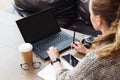 Back view. Young businesswoman sitting in office working on laptop computer. holding pen. Business education for adult Royalty Free Stock Photo