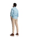 back view of young casual man holding hands in pockets and standing Royalty Free Stock Photo