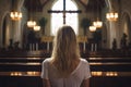 Back view of young caucasian woman in catholic church