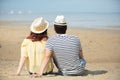 back view young couple sitting on sandy beach Royalty Free Stock Photo