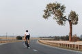 Back view of young cyclist riding on paved road Royalty Free Stock Photo