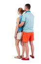 Back view of young embracing couple in shorts hug and look. Royalty Free Stock Photo