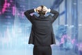 Back view of young european businessman standing and looking at downward purple forex chart on blurry office background. Crisis Royalty Free Stock Photo