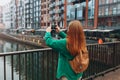 Back view of young European tourist makes photo or video on smartphone at city of Gdansk, Poland. Hipster girl with Royalty Free Stock Photo