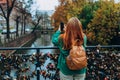 Back view of young European tourist makes photo or video on smartphone at city of Gdansk, Poland. Hipster girl with Royalty Free Stock Photo