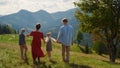 Back view family walking on mountains hill sunny day. Summer vacation together. Royalty Free Stock Photo