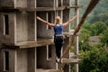 Back view of fearless woman walking on a slackline