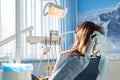 Back view of young female patient visiting dentist office sitting at dental chair. Clinic stomatology