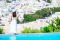 Back view of young girl relaxing on the edge of pool with amazing view on Mykonos, Greece Royalty Free Stock Photo