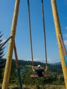 man traveler enjoying of swinging on heavenly swing and mountain view