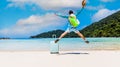 Back view of Young man  traveller with hat jumping on the beach which feeling happy and freedom concept Royalty Free Stock Photo