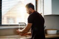 Back view of a young man washing dishes Royalty Free Stock Photo