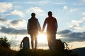 Back view of young persons admiring the sunset in mountains holding hands