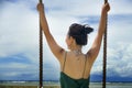 Back view of young pretty and happy Asian Chinese woman holding swing rope having fun Royalty Free Stock Photo