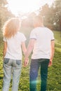 back view of young redhead couple holding hands and walking together Royalty Free Stock Photo