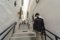 Back view of a young tourist with a backpack wearing a medical mask in Arcos de la Frontera