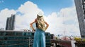 Back view of young woman in blond hair happy lifestyle a holiday in Summer as stretching with blue sky in the city background Royalty Free Stock Photo