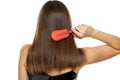 Back view of young woman combing her long hair Royalty Free Stock Photo