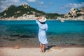 Back view of young woman in hat relax in amazing Sardinia beach