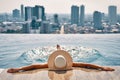 Back view of young woman in hat relaxing in swimming pool on the roof top of hotel Royalty Free Stock Photo