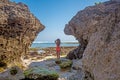 Young woman in swimsuit between two rocks on the beach Royalty Free Stock Photo