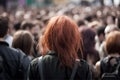 Back view of young woman with punkish red hair in crowd. Royalty Free Stock Photo
